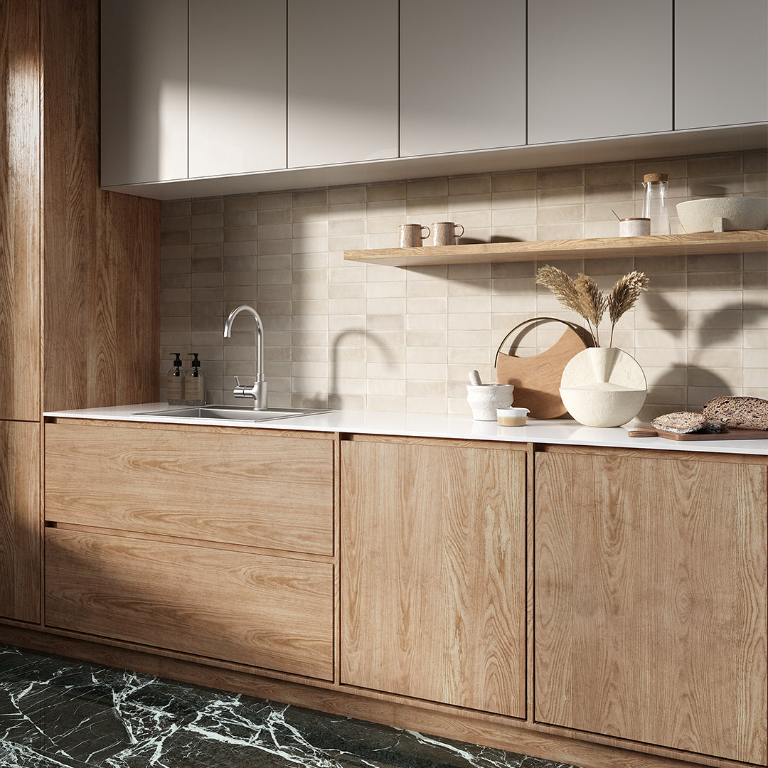 Modern kitchen with wooden cabinets, marble floor, and white countertops.