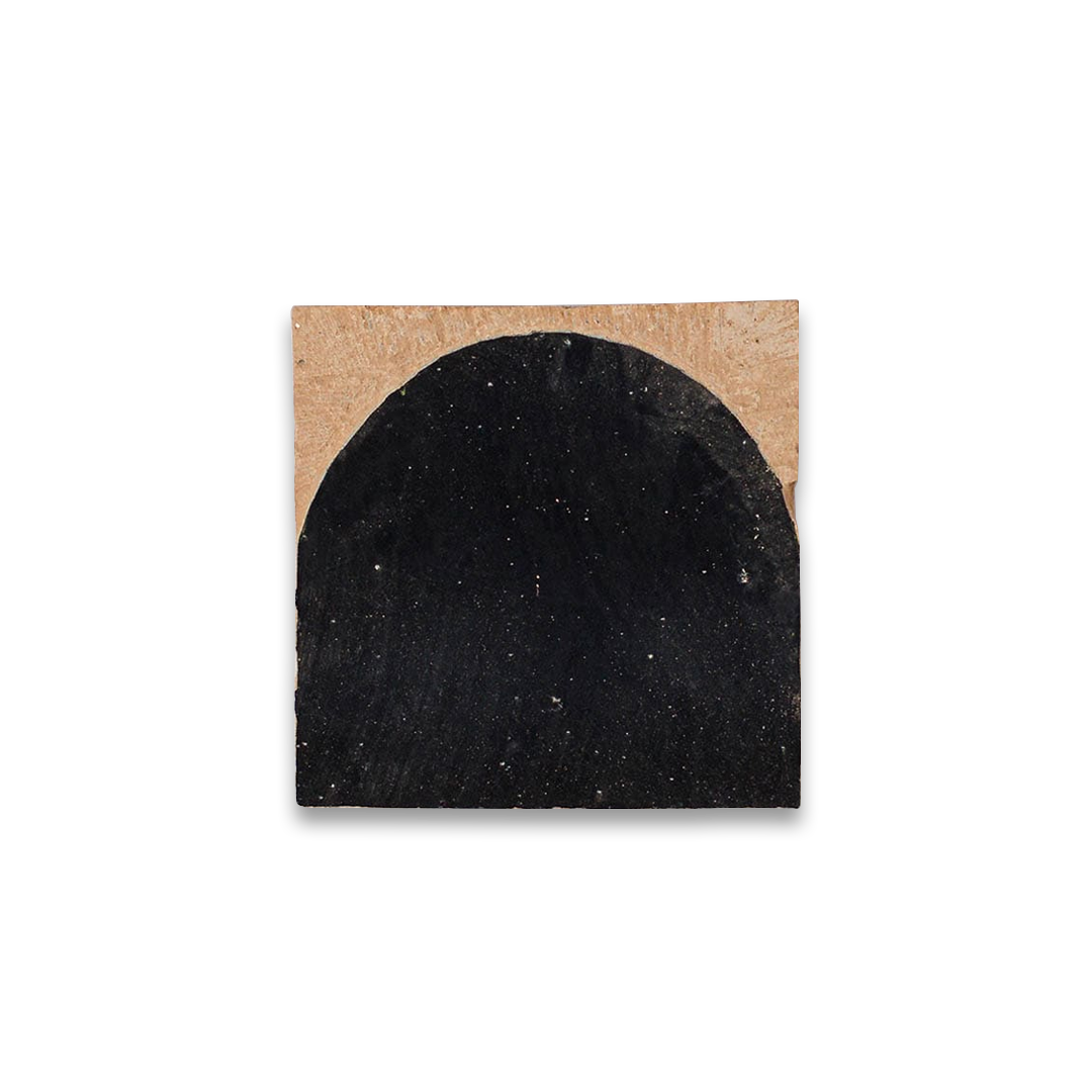 Black arc-shaped coaster on a cardboard backing