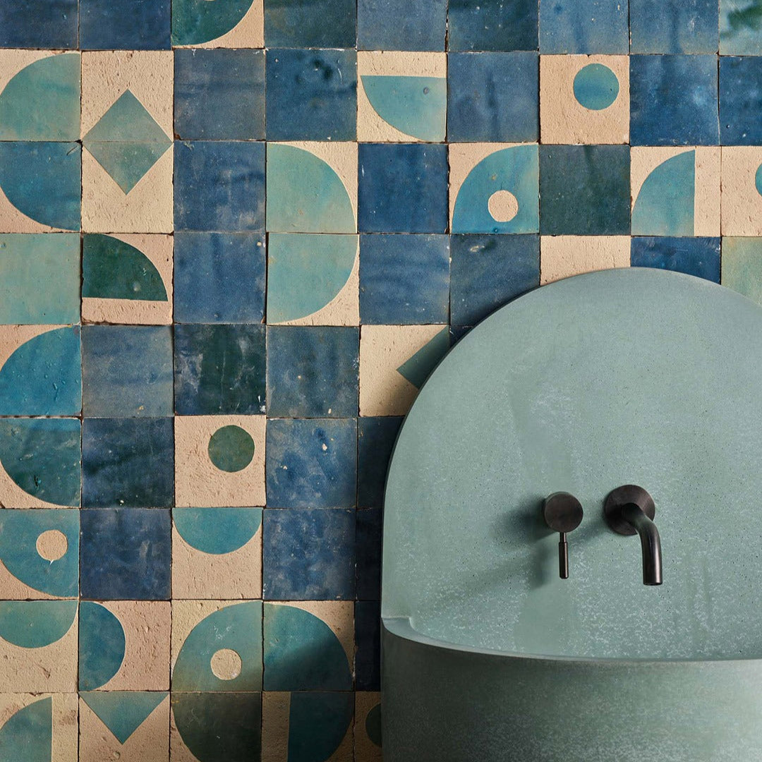 Geometric tile pattern with a green sink and black fixtures