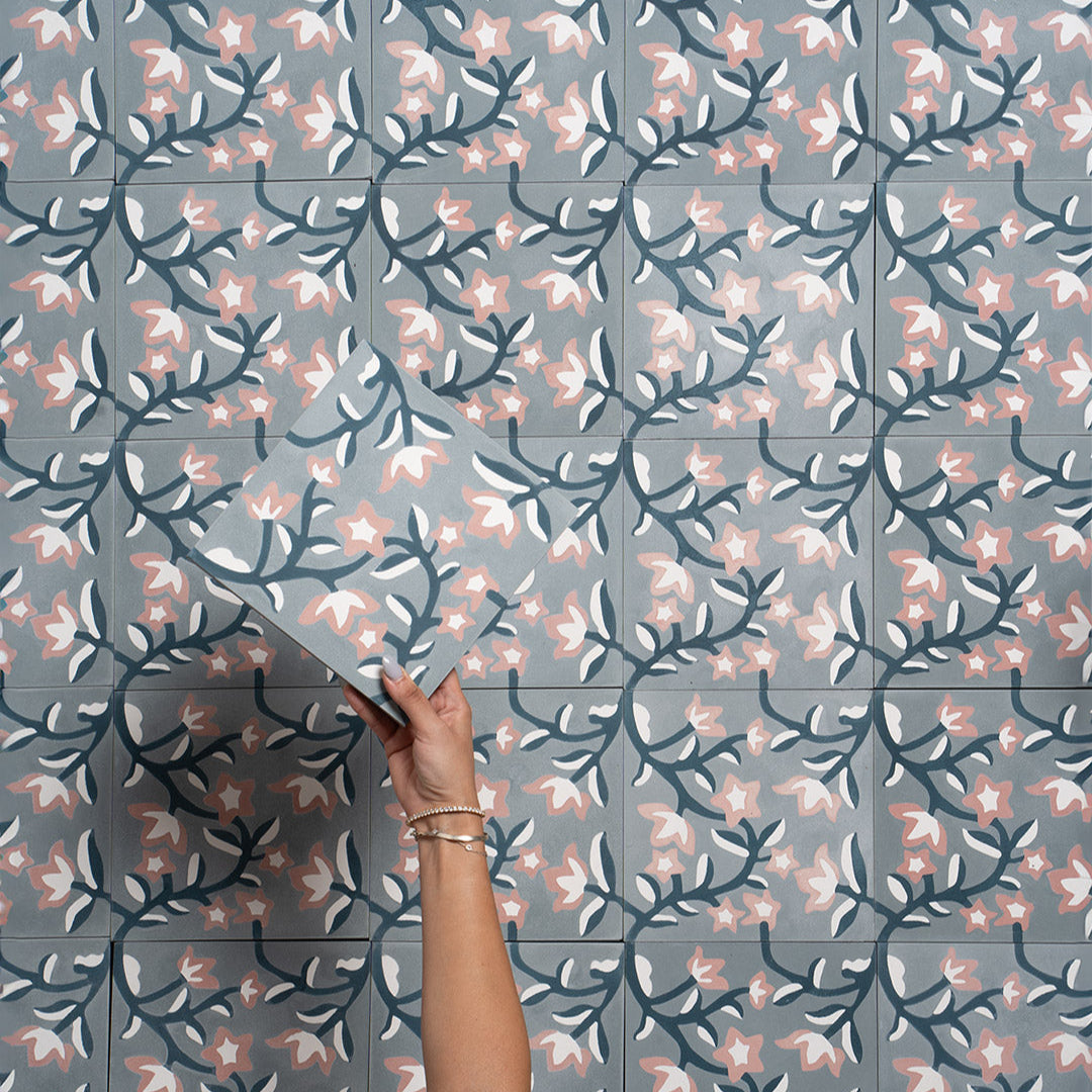 Cement tile featuring a floral pattern with pink and white blossoms on dark teal vines over a soft gray background, matte finish, ideal for vintage, bohemian, or Mediterranean interiors.