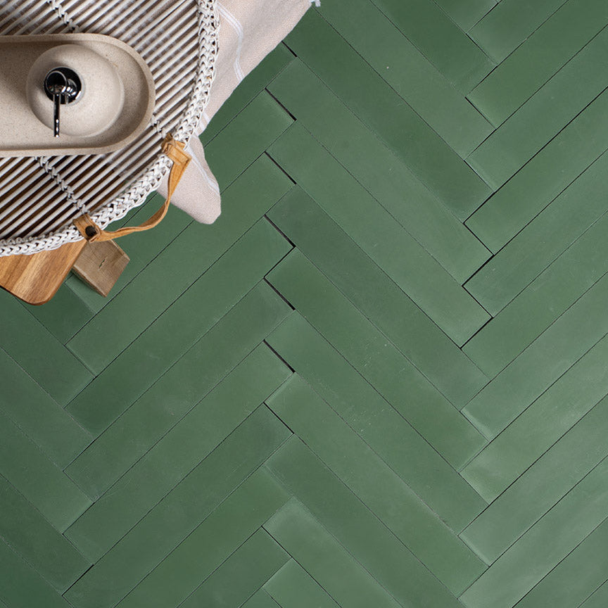 A rectangular sage green tiles arranged in a herringbone pattern, matte finish, ideal for modern, minimalist, or Scandinavian interior flooring and wall applications.