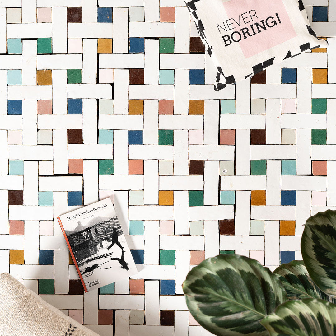 Colorful geometric tile pattern with a magazine titled 'Never Boring!' on top.