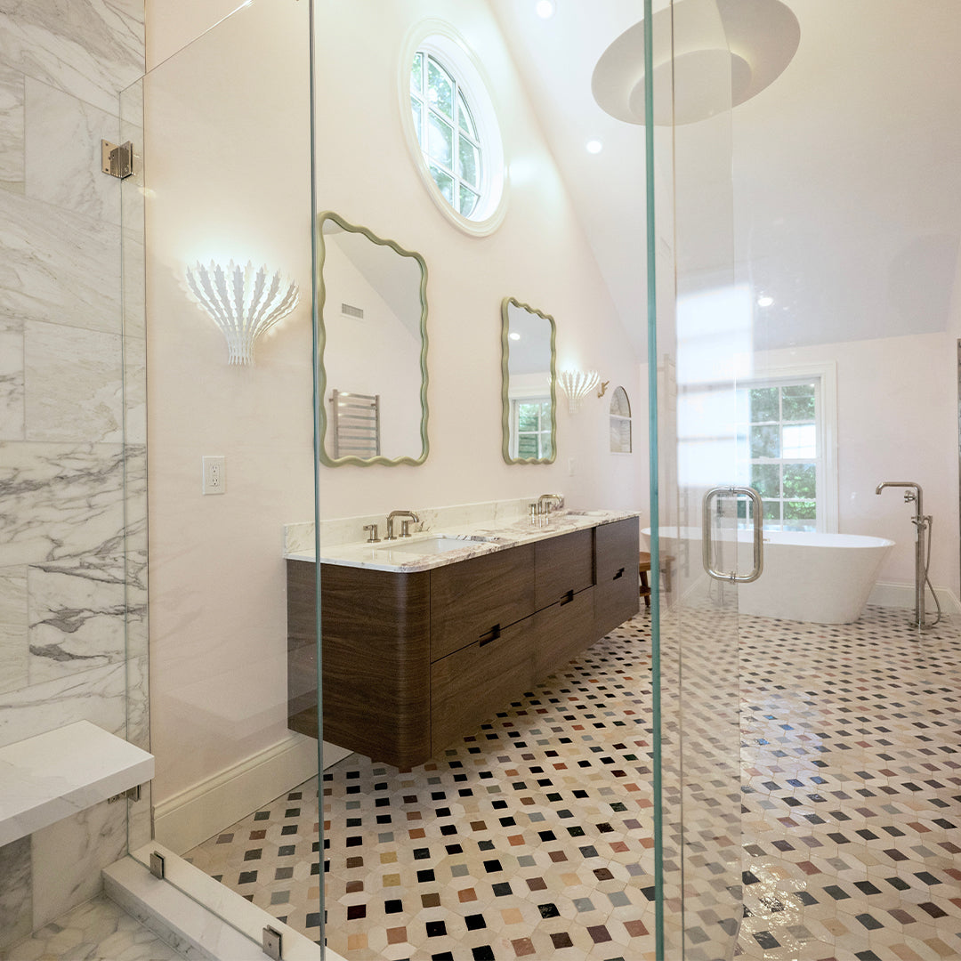 Modern bathroom with glass shower enclosure, wooden vanity, and tiled floor.