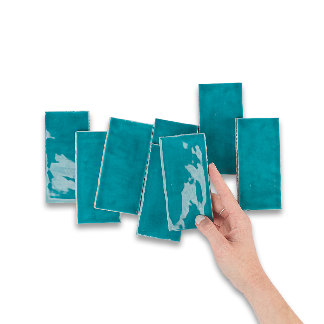 Hand holding a teal square with white abstract design against a white background