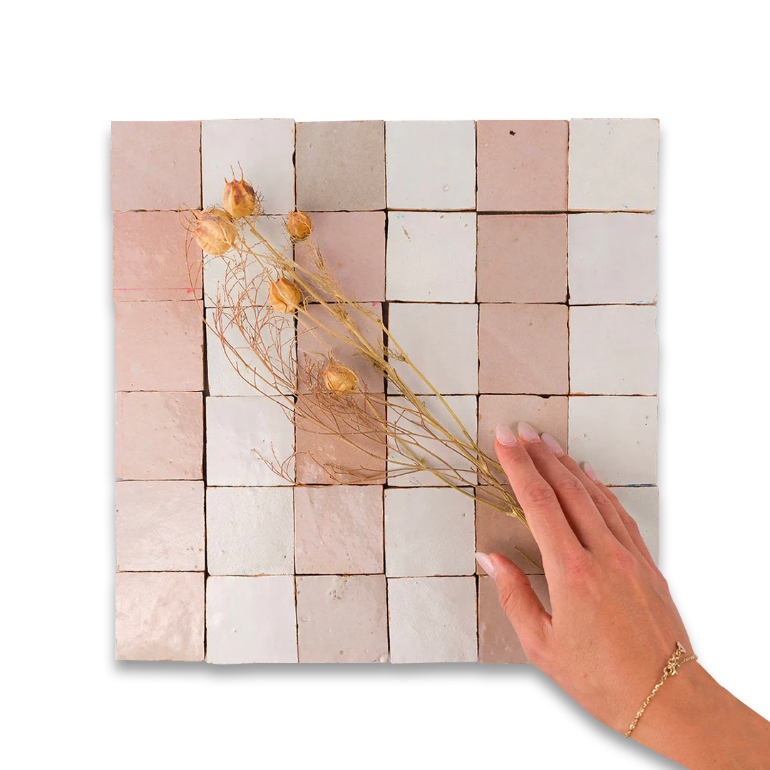 Handmade tile artwork with dried flowers on a white background