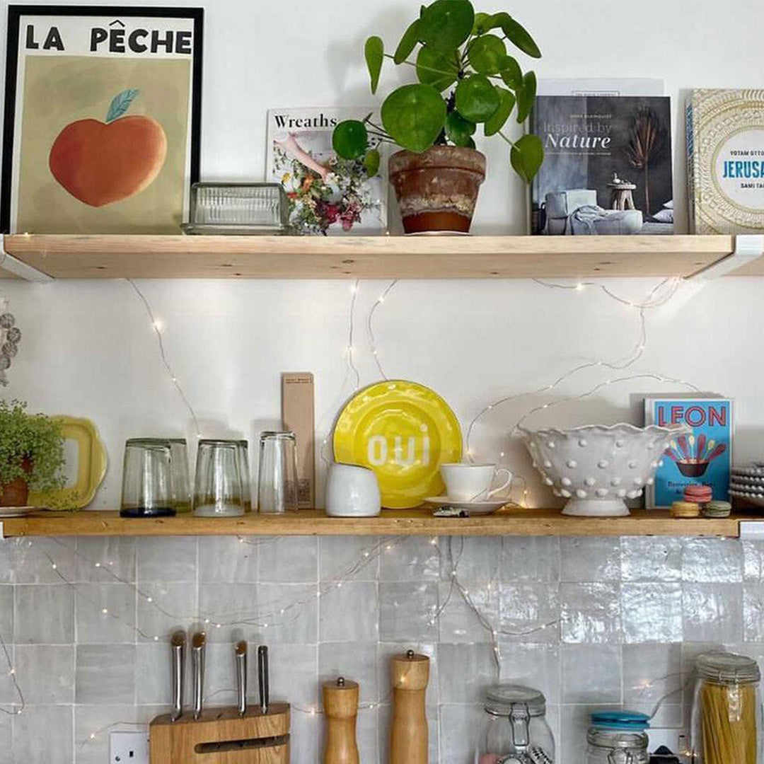 Kitchen shelves with decor items against a tiled wall