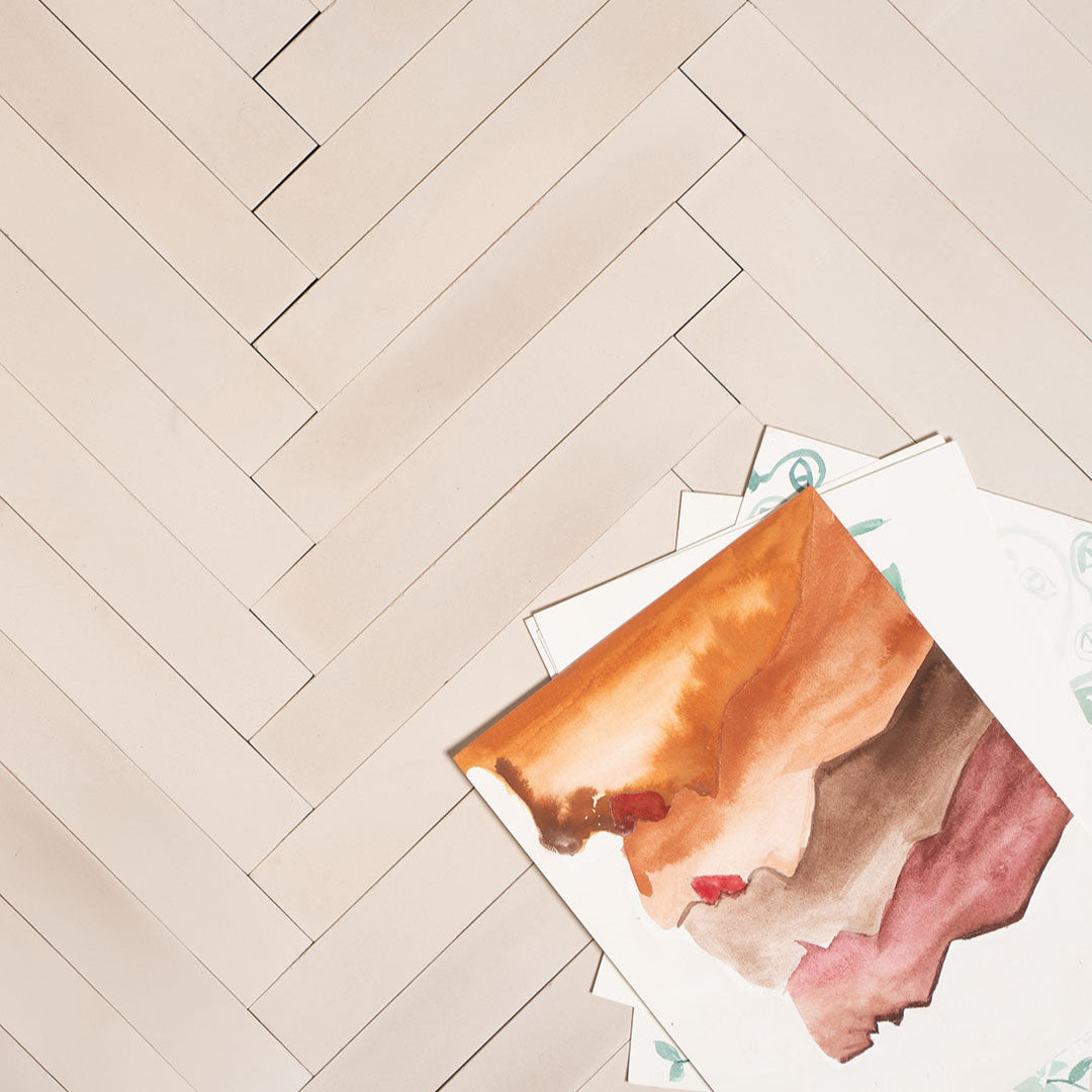 Rectangular cream tiles arranged in a herringbone pattern, showcasing a smooth matte finish and minimalist design ideal for modern kitchens, bathrooms, and feature walls.