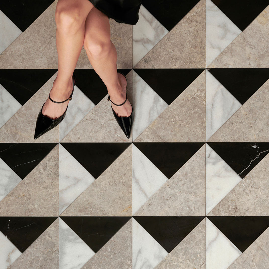 Person wearing black high heels on a geometric patterned floor