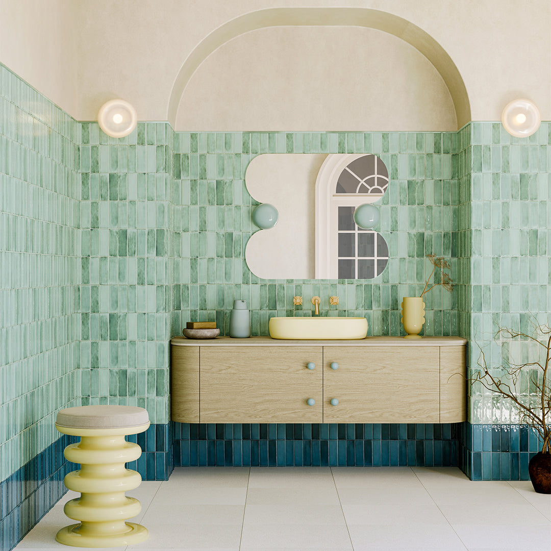 Bathroom with green mosaic tiles and a wooden vanity.