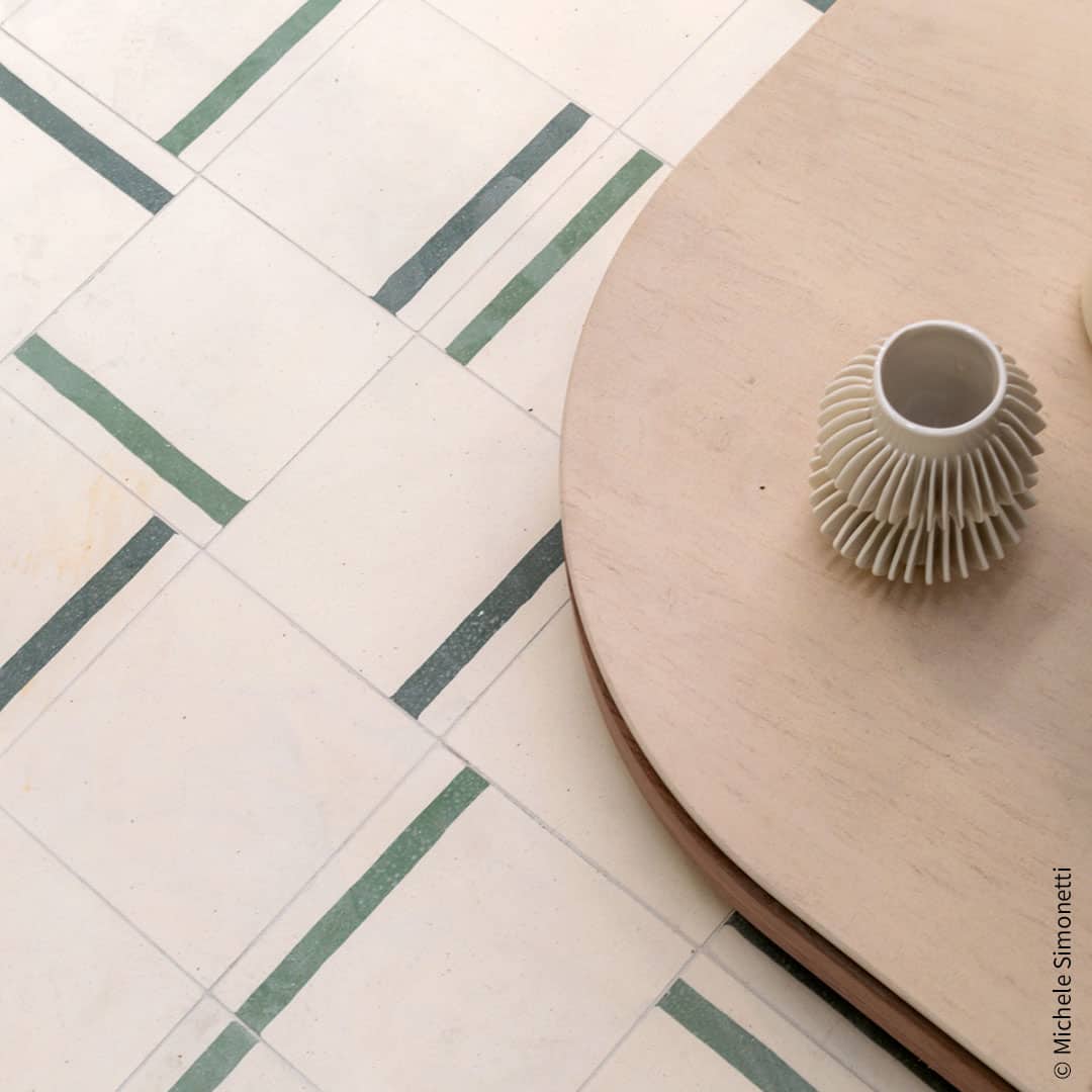 A decorative tile featuring a smooth soft beige background complemented by a bold green accent stripe, perfect for modern interior designs.