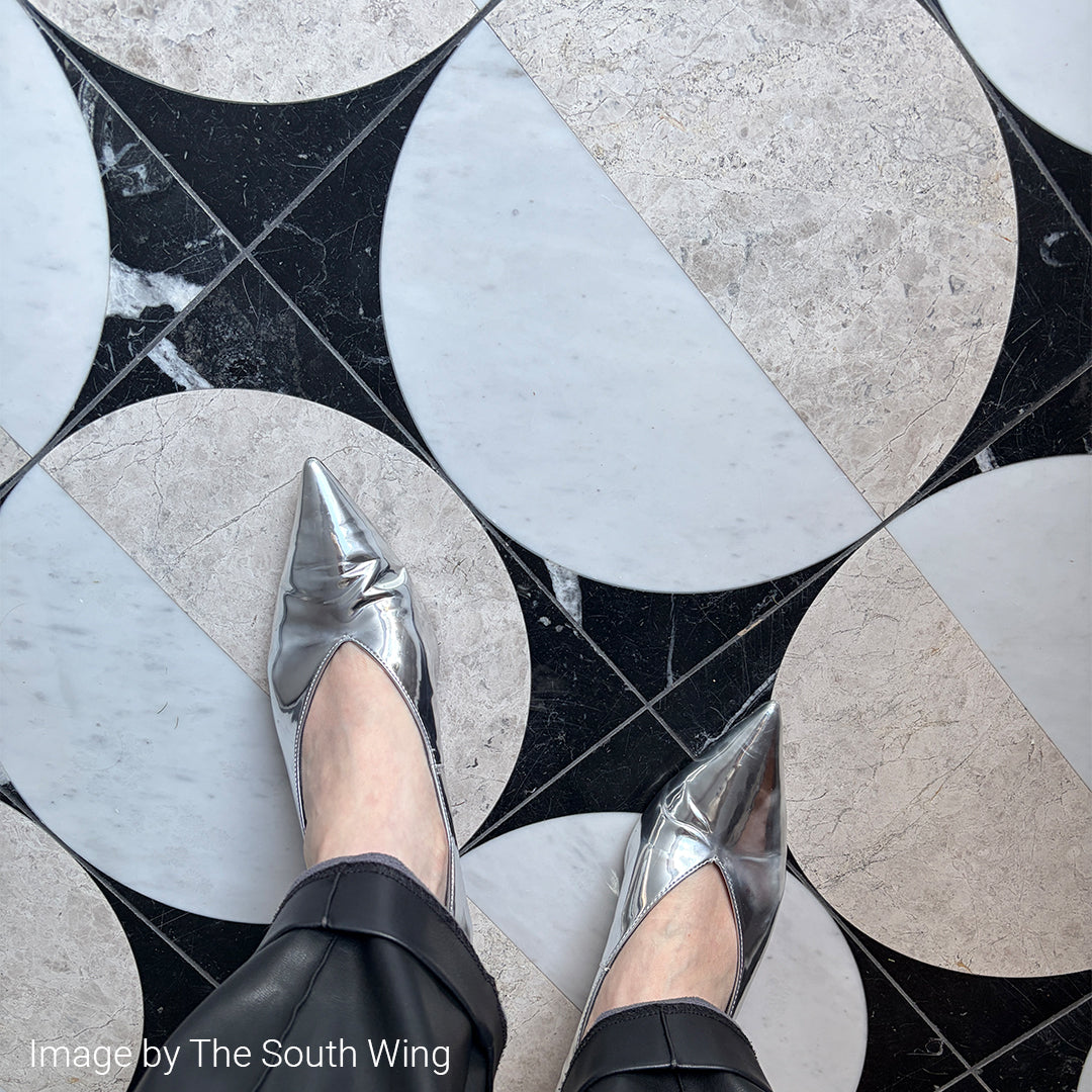 Silver pointed-toe shoes on a patterned floor