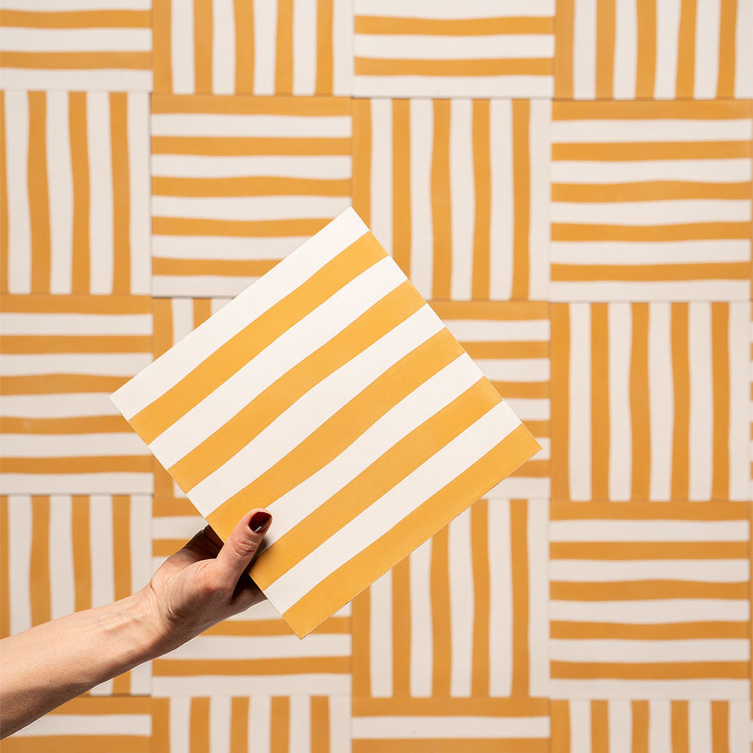 Cement tile featuring alternating vertical stripes in warm ochre orange and white, matte finish, handcrafted surface, ideal for Mediterranean, coastal, or contemporary interior flooring and wall décor applications.