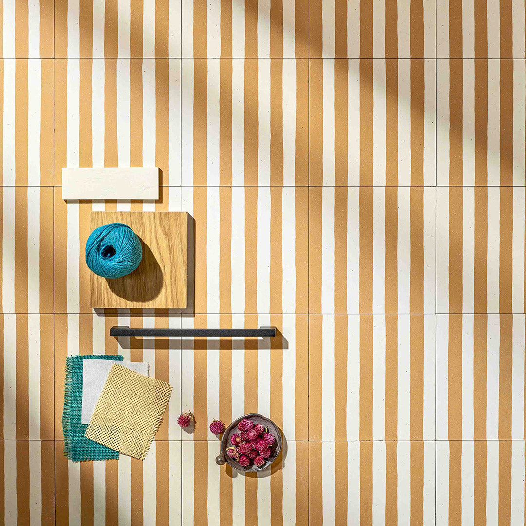 Cement tile featuring alternating vertical stripes in warm ochre orange and white, matte finish, handcrafted surface, ideal for Mediterranean, coastal, or contemporary interior flooring and wall décor applications.