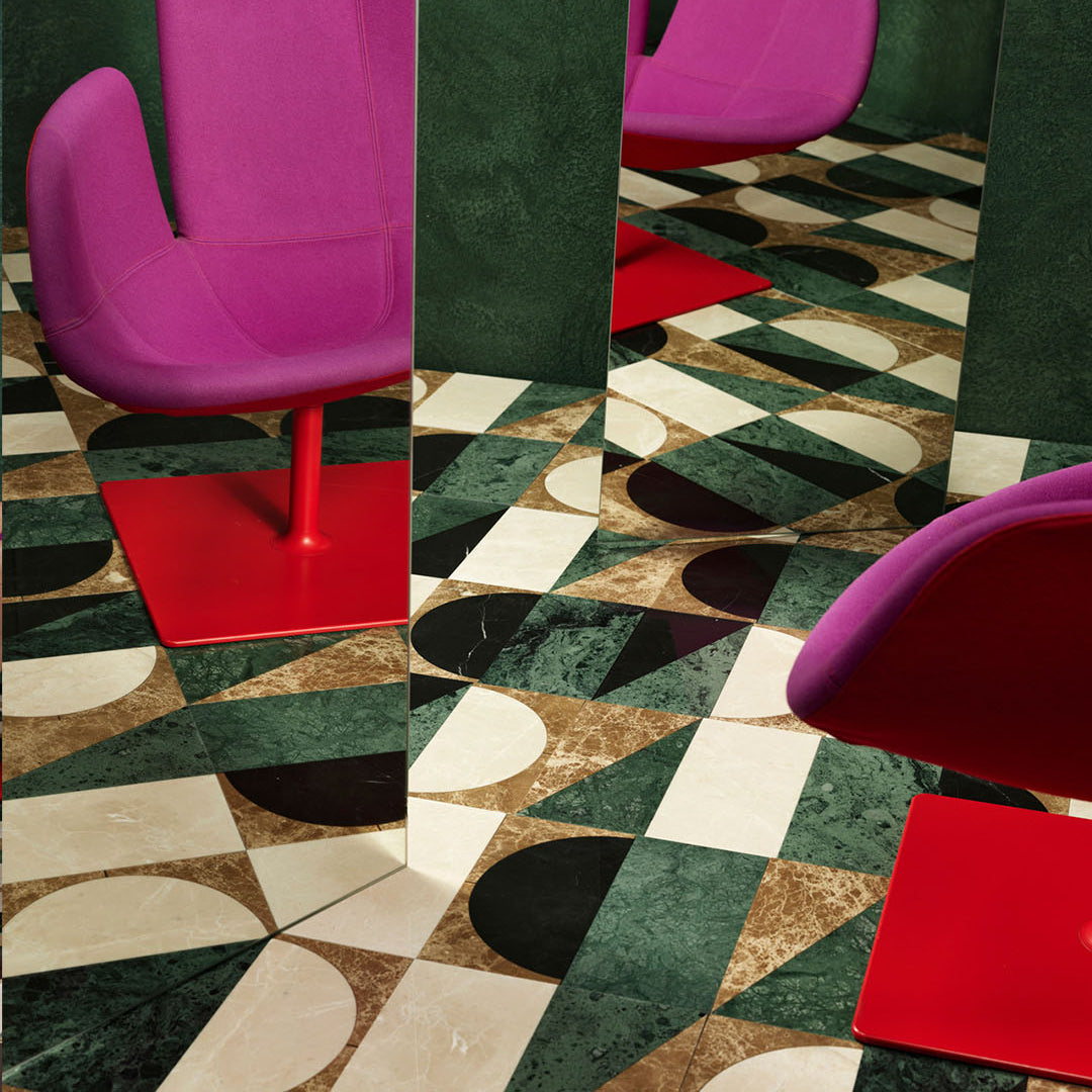 Modern chairs with vibrant purple and red seats on a geometric patterned floor.