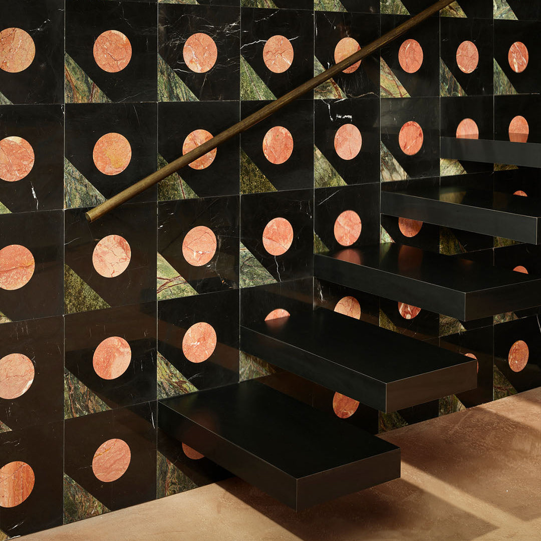 Black staircase with geometric patterned walls featuring circular designs.