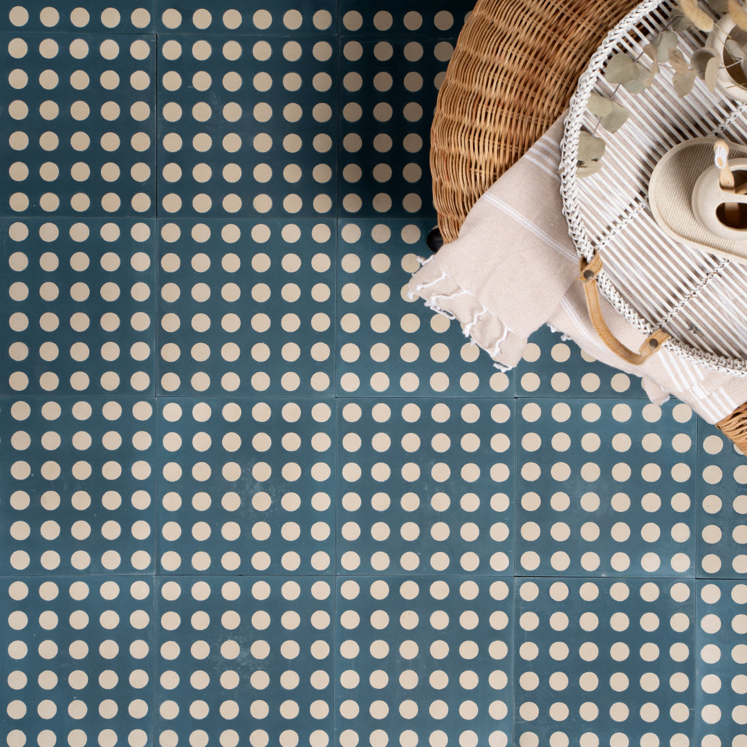 Cement tile featuring a teal blue background with evenly spaced white polka dots, matte finish, ideal for retro, playful, or contemporary interior flooring and wall décor applications.