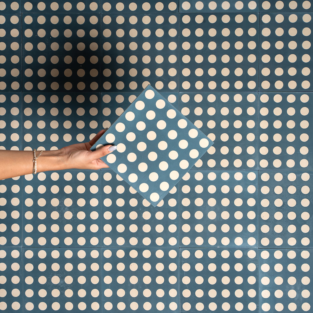 Cement tile featuring a teal blue background with evenly spaced white polka dots, matte finish, ideal for retro, playful, or contemporary interior flooring and wall décor applications.