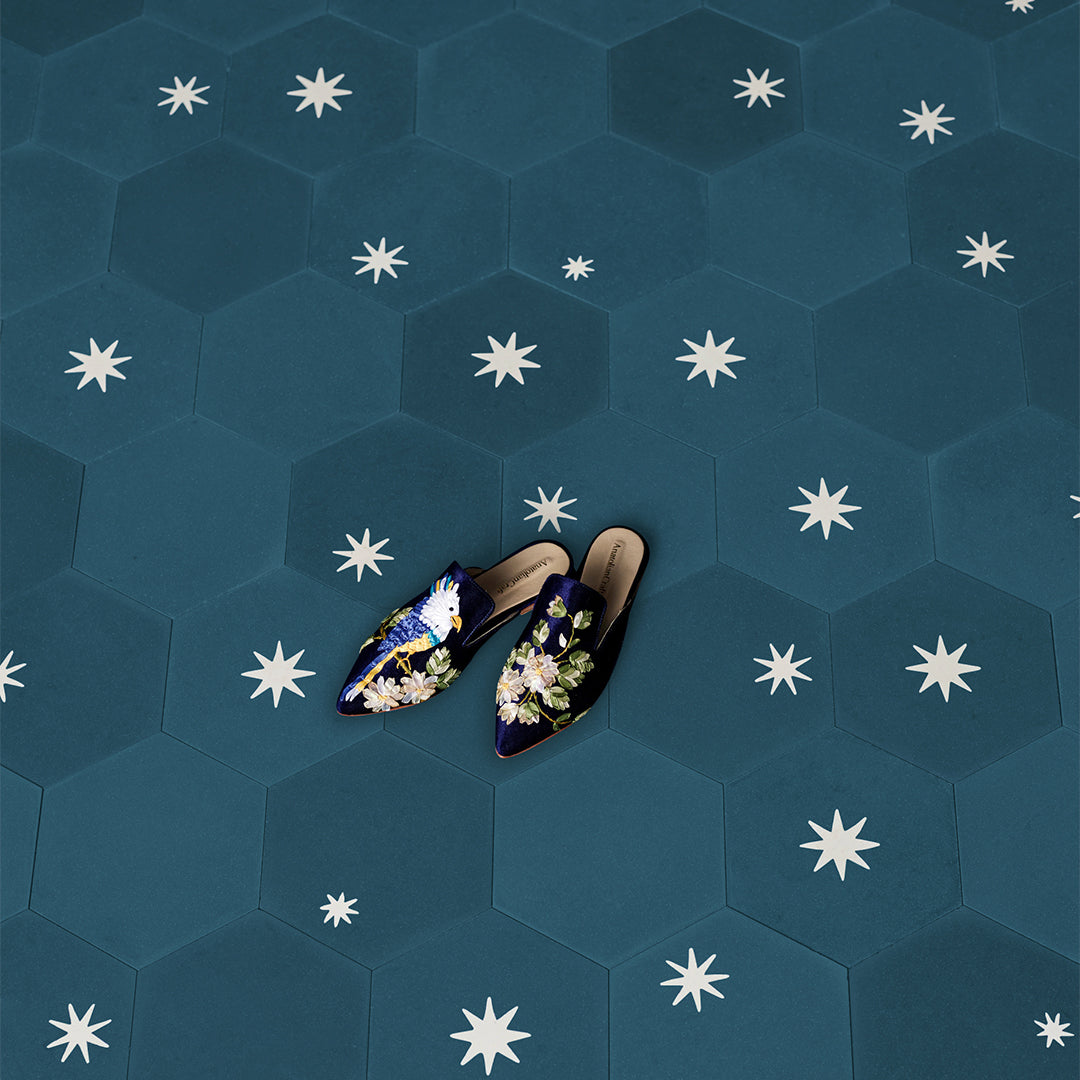 Cement tile featuring a hexagonal shape in deep teal blue with white starburst motifs, matte finish, ideal for modern, celestial, or Mediterranean interior flooring and wall décor applications.