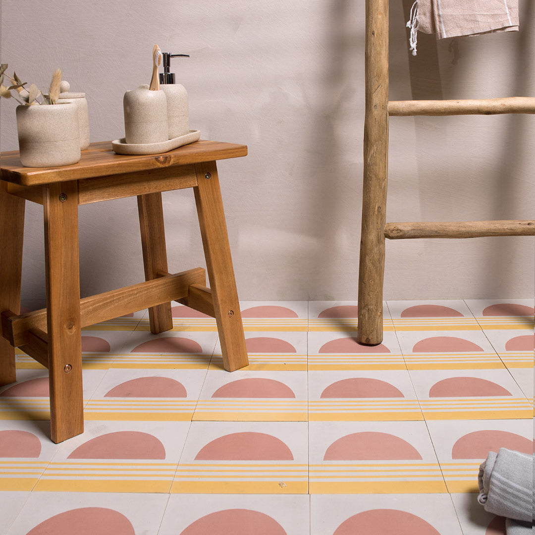 Square cement tile featuring a minimalist sunset design with a pink semicircle sun above soft yellow horizontal stripes, matte finish, ideal for modern, coastal, or bohemian interior wall and floor décor.