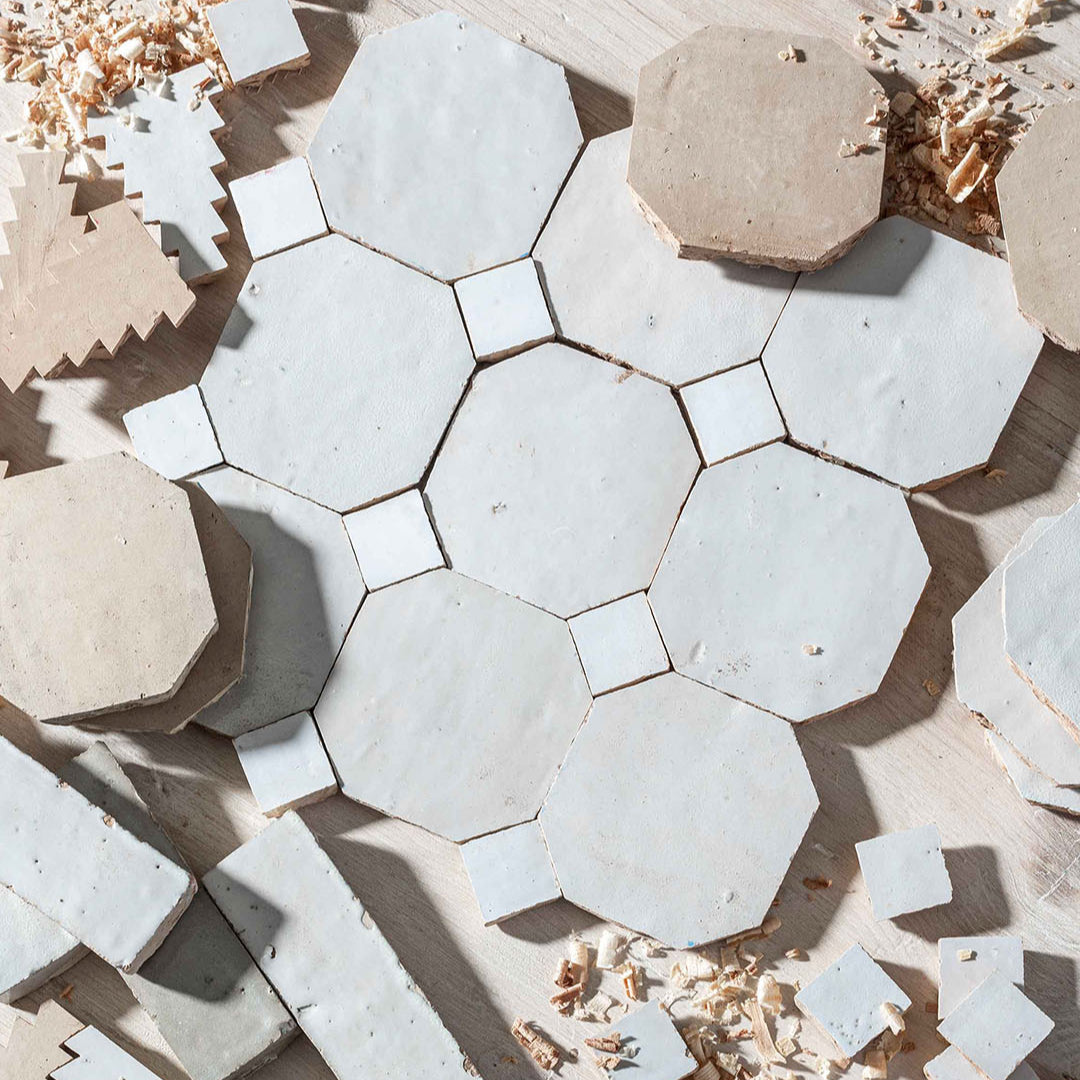 Hexagonal stone tiles in various shades of gray and beige on a wooden surface.