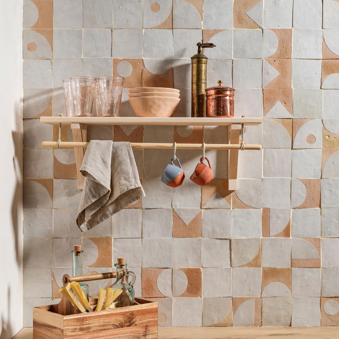 Bathroom with geometric tile pattern, wooden shelf, and copper fixtures.