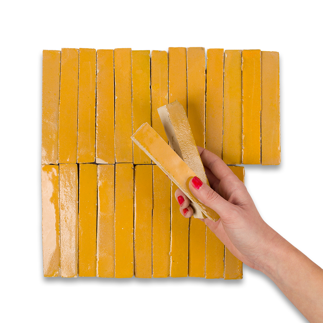 Hand holding a yellow block over a grid of yellow blocks on a white background