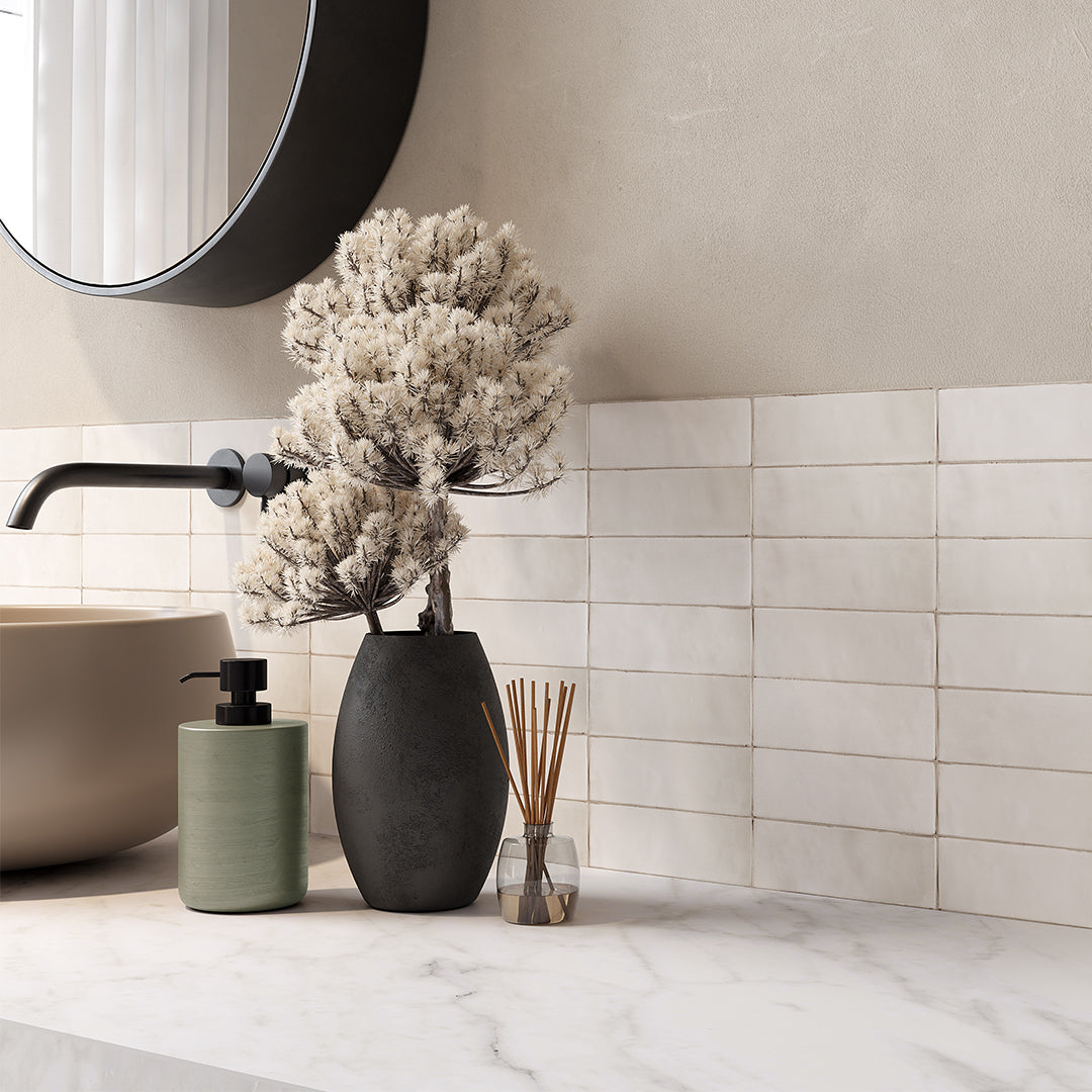 Bathroom setting with a vase, soap dispenser, and decorative elements on a marble countertop.