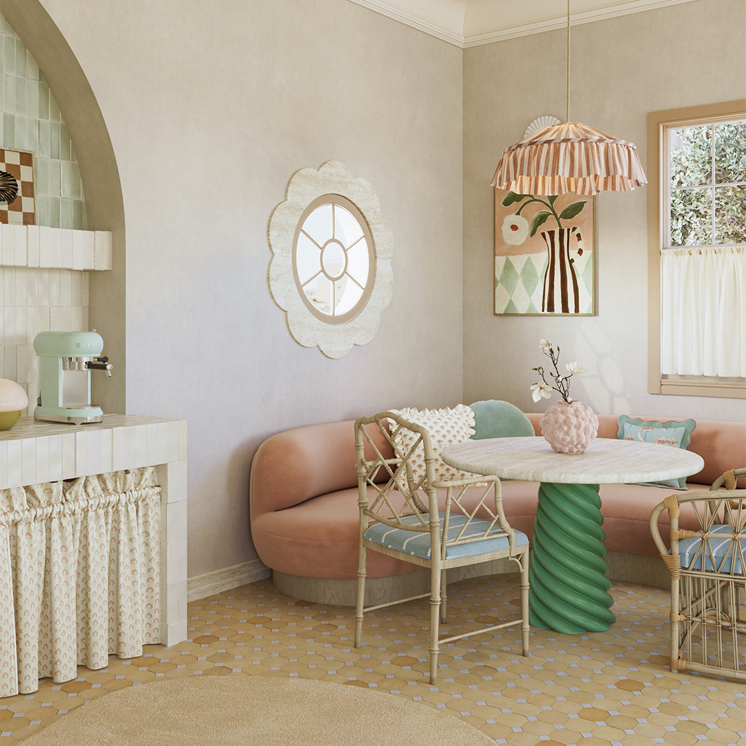 Modern interior design with a pink sofa, green table, and decorative elements.
