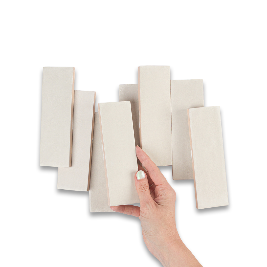 Hand holding a set of tiles in beige color swatches.