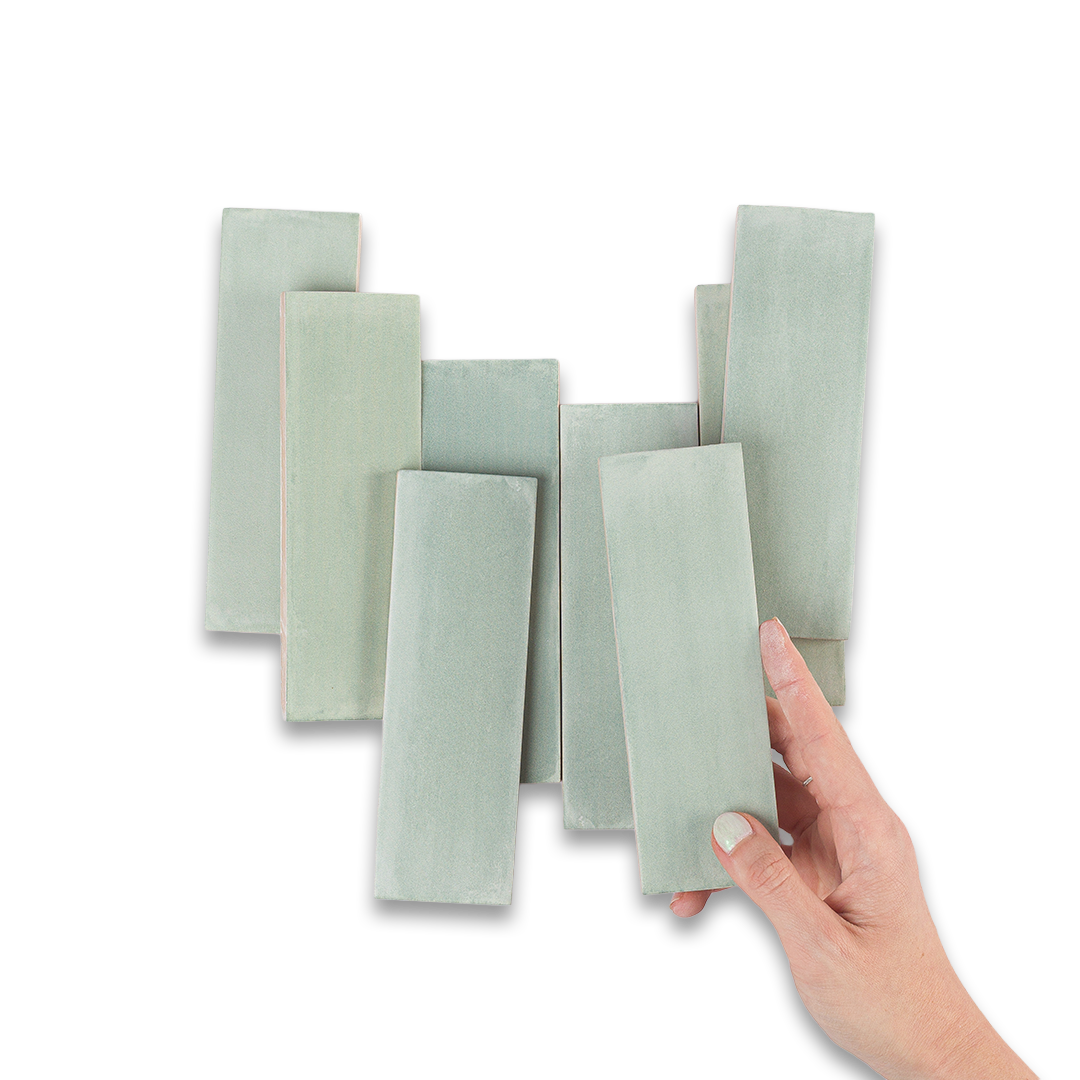 Set of light green rectangular tiles with a hand holding one tile against a white background