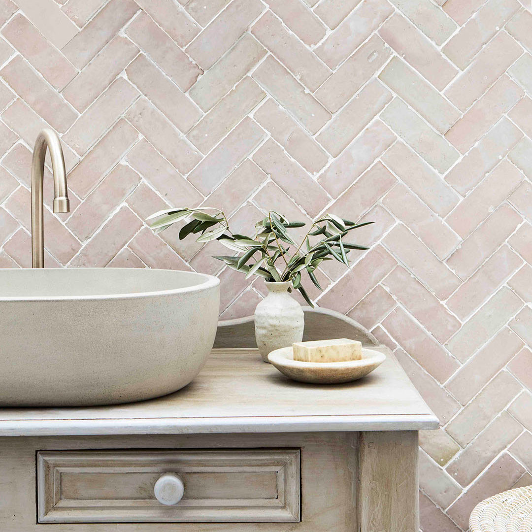 Bathroom with a stone sink and tiled wall in a herringbone pattern