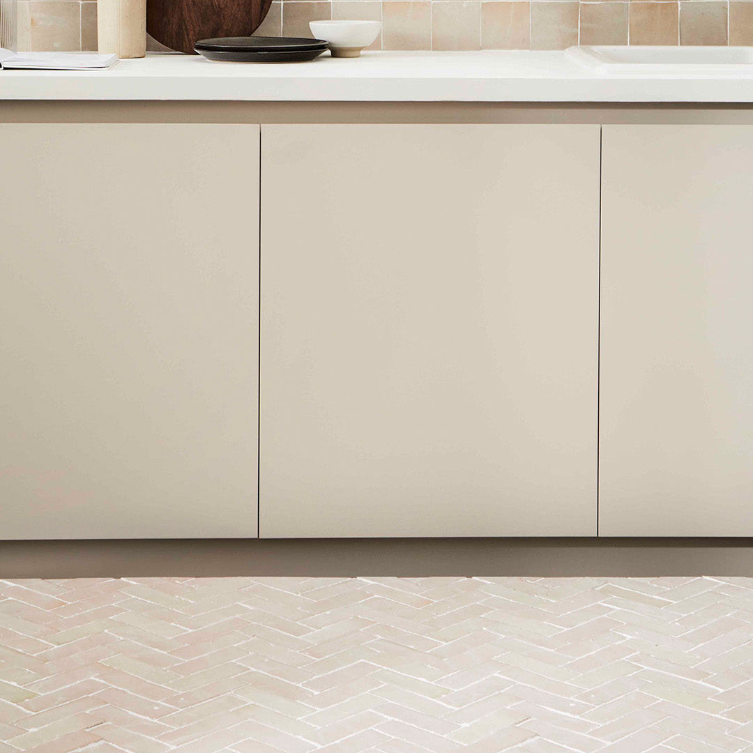 Beige kitchen cabinets with a tiled floor