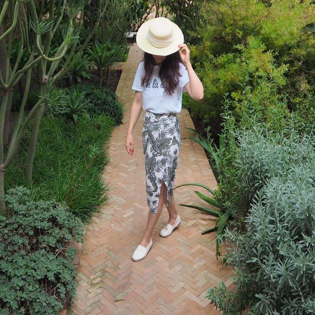 Woman walking on a garden path surrounded by greenery