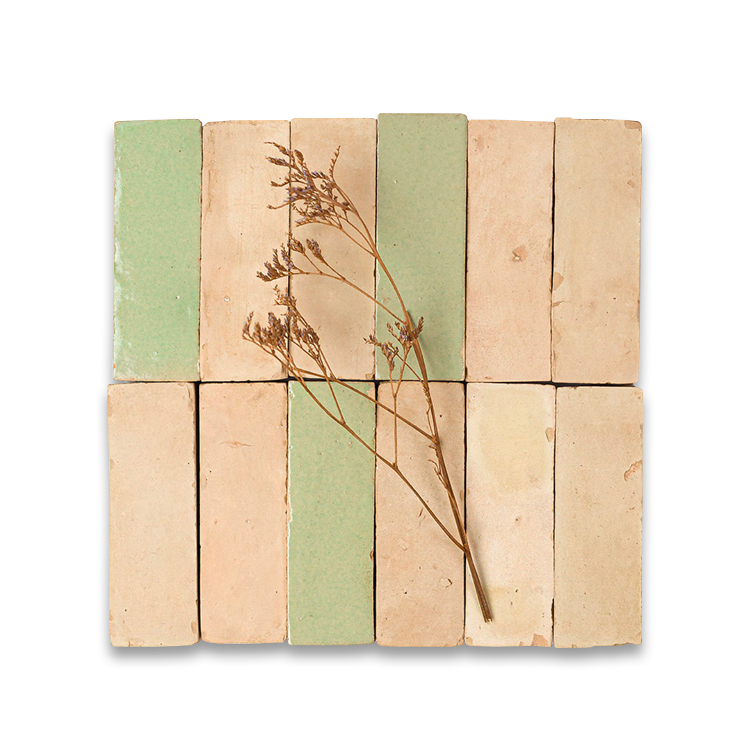 Beige and green bathroom tiles arranged in grid with dried plant stem, blending natural elements and interior design.