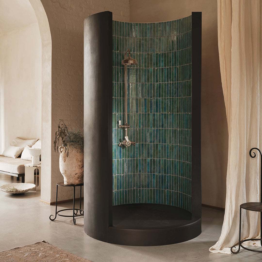 Modern shower enclosure with green tiles in a bathroom setting