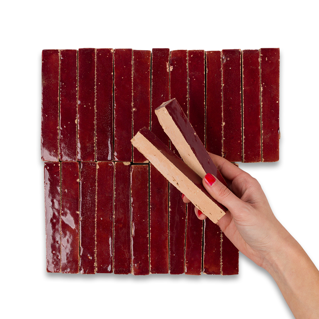Hand holding a piece of dried meat next to a woven mat of similar meat on a white background
