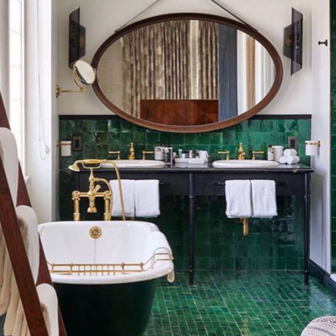 Luxurious bathroom with green tiles, black vanity, and gold fixtures.