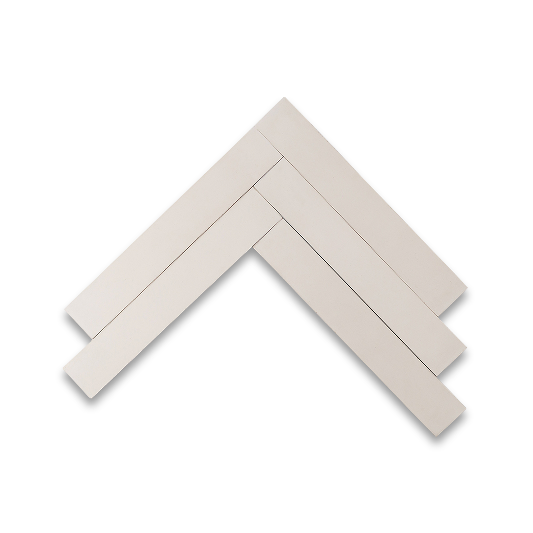 Dirty white cement tiles arranged in a herringbone pattern, showcasing a matte finish and subtle beige undertones, ideal for rustic, modern, or industrial-style flooring and walls.