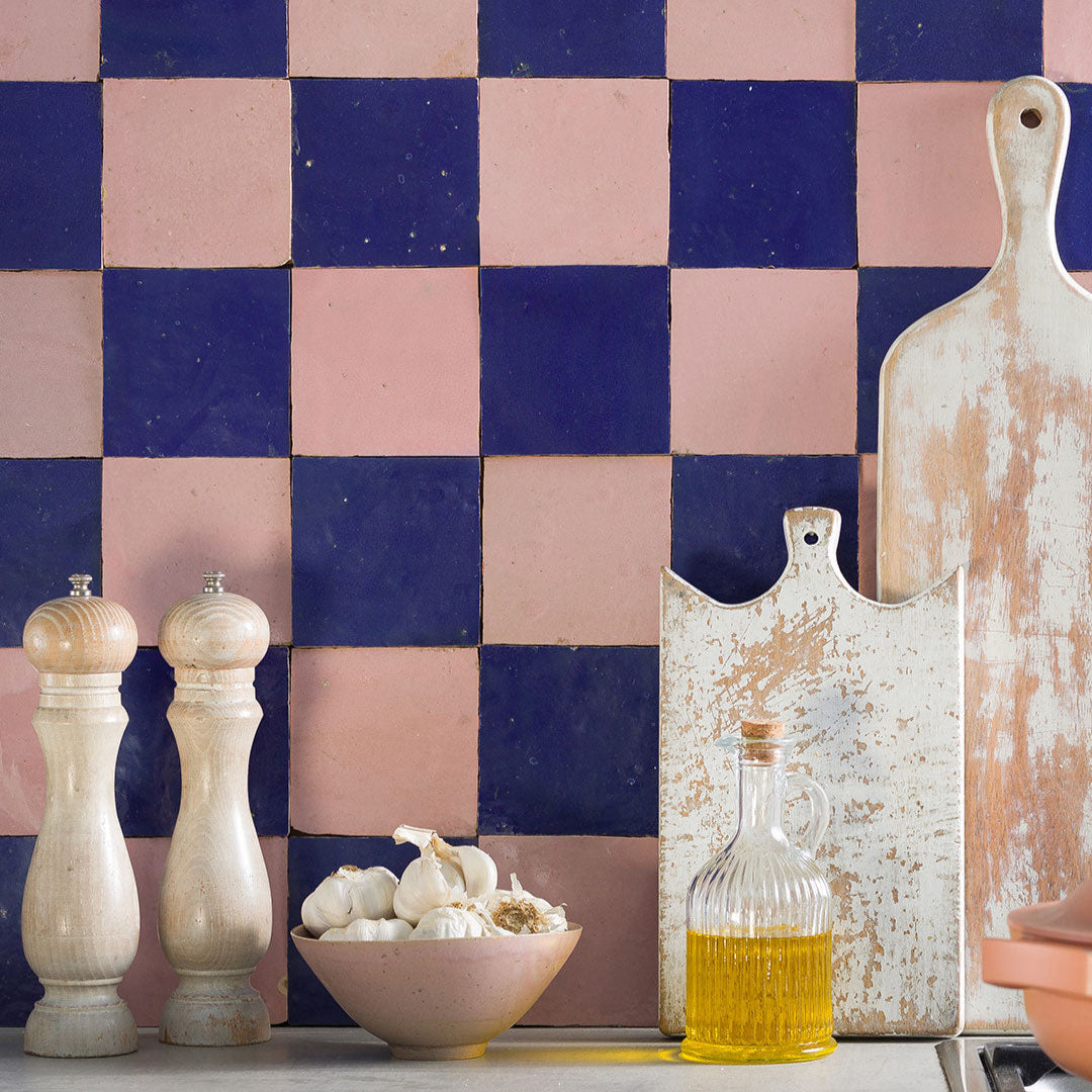 Decorative kitchen scene with checkered tile wall, cutting board, and kitchen items.