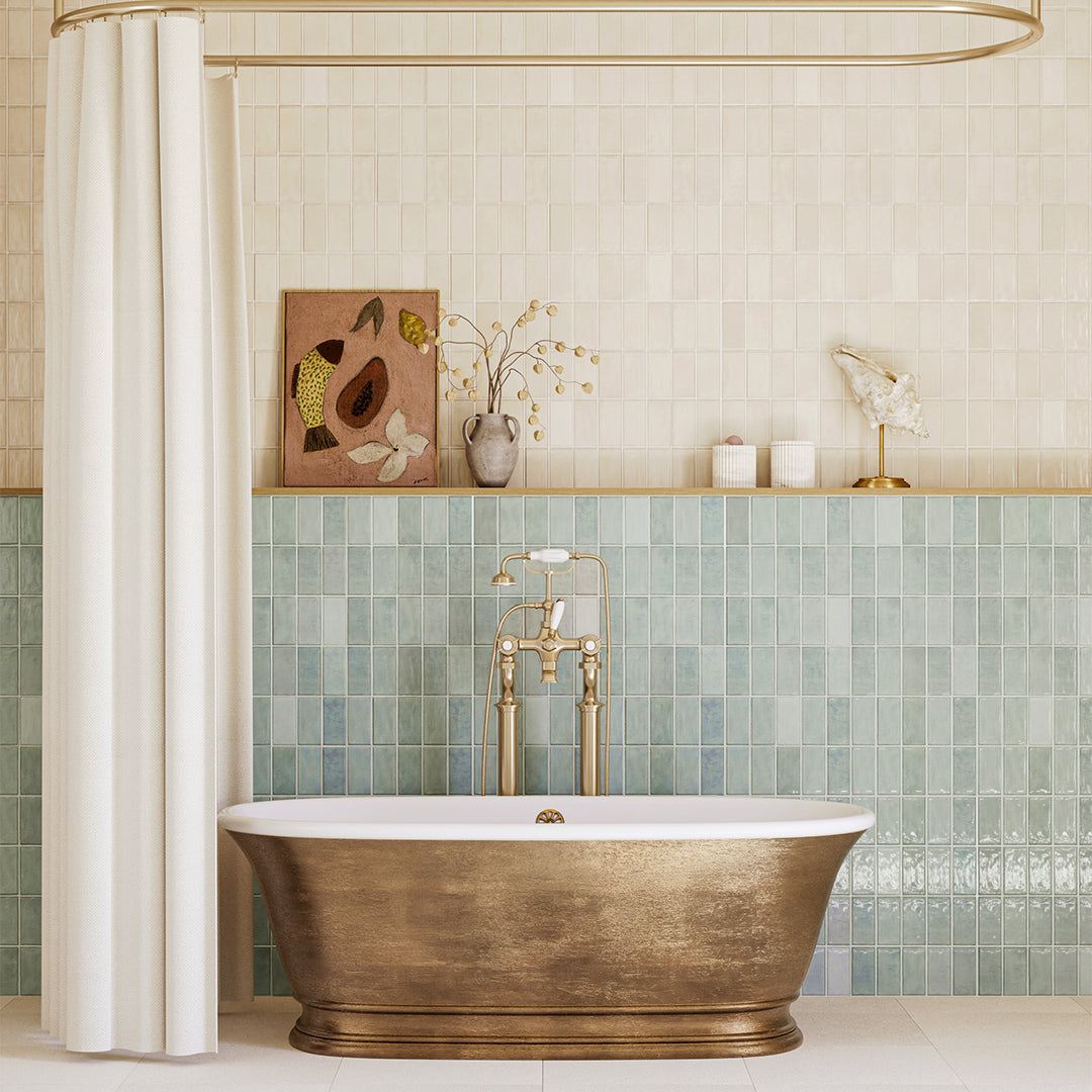Modern bathroom with a freestanding bronze bathtub, green tiled wall, and decorative elements.