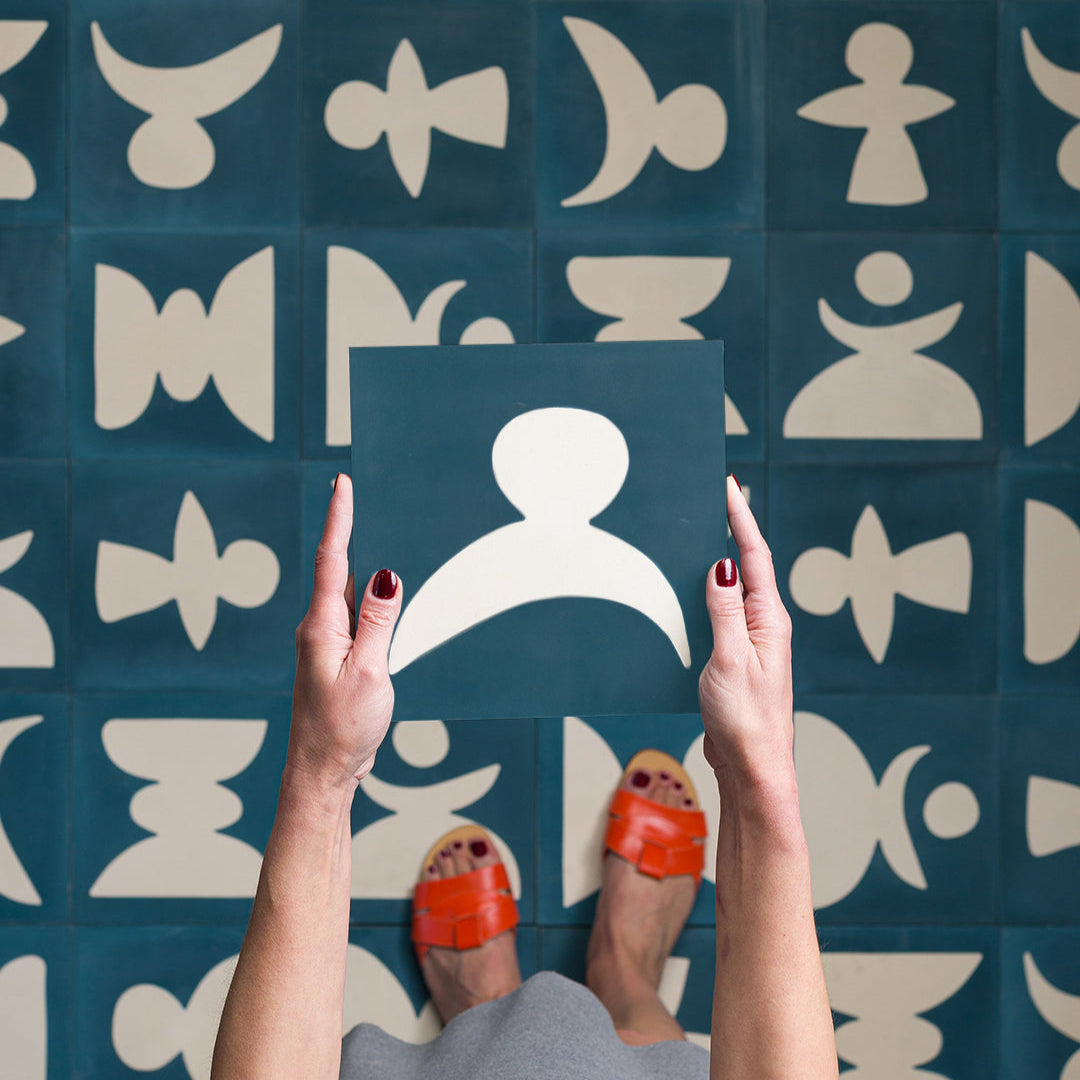 Cement tile featuring abstract geometric white shapes on a deep teal blue background, matte finish, ideal for modern, artistic, or mid-century interior flooring and wall décor applications.