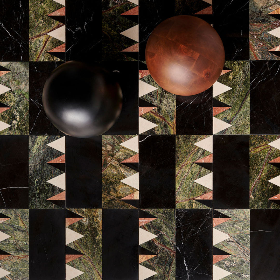 Two spherical objects on a checkered pattern with geometric shapes