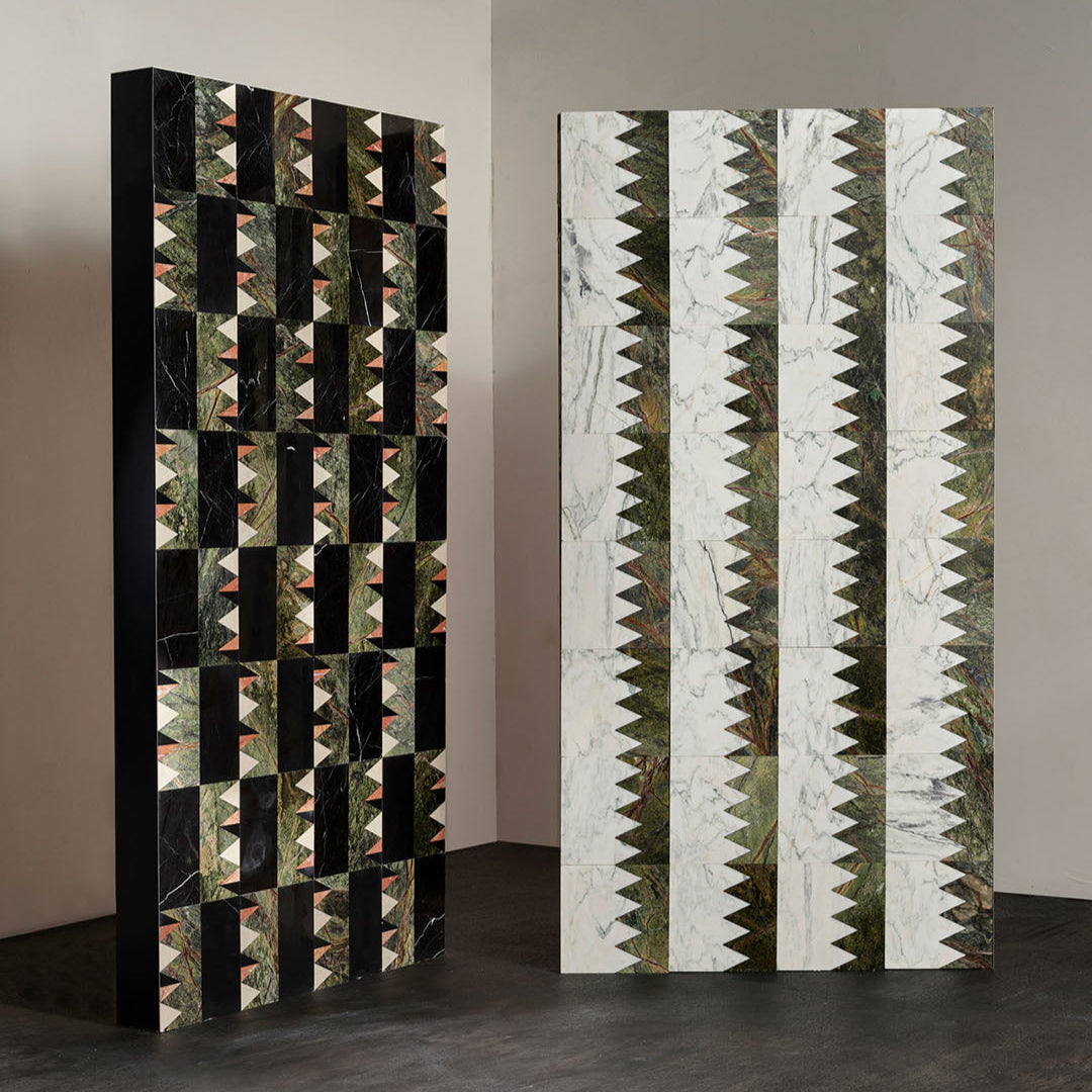 Two decorative room dividers with geometric patterns on a plain wall.