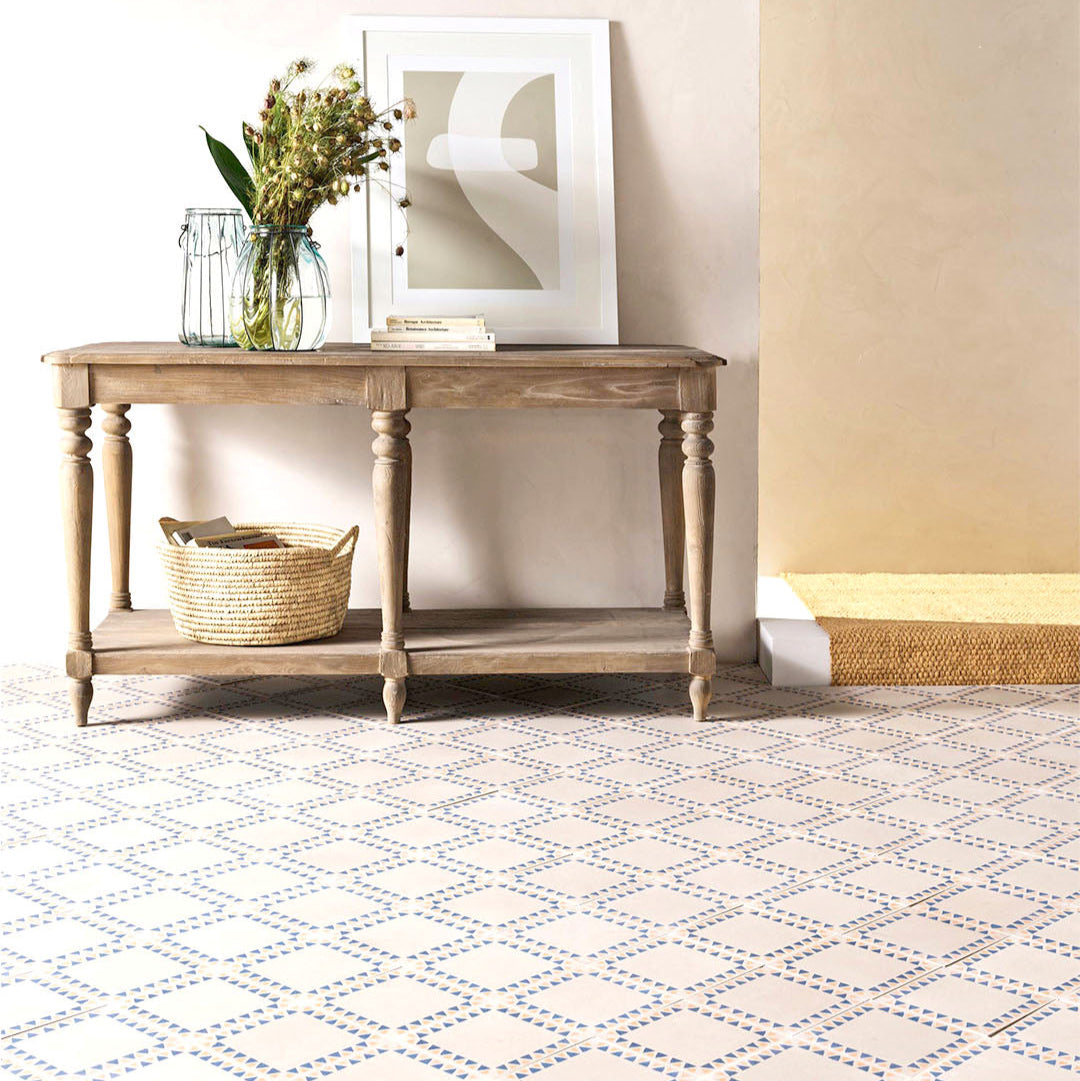 Square cement tile featuring a cream base with a geometric border of alternating blue and terracotta triangles, handcrafted matte finish, ideal for Mediterranean, bohemian, or contemporary interior flooring and wall décor.