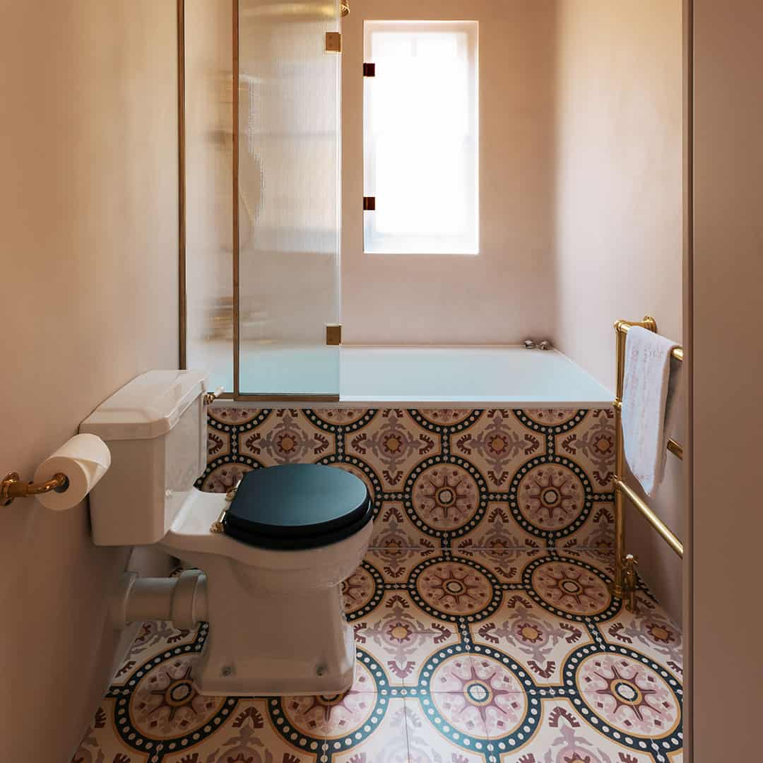 Cement tile featuring an ornate floral and circular motif in dusty pink, terracotta red, mustard yellow, and black accents, matte finish, ideal for Mediterranean, vintage, or eclectic interior flooring and wall décor applications.