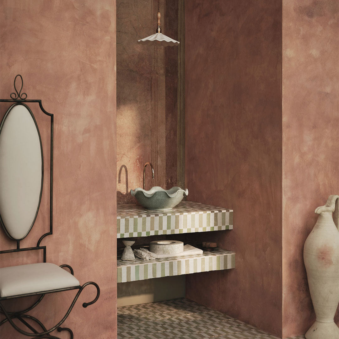 Bathroom interior with pink walls, a checkered vanity, and decorative elements.