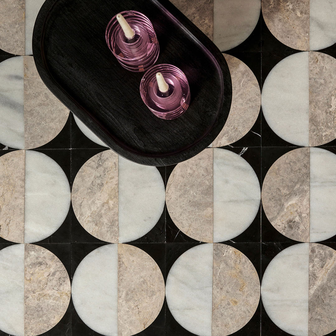 Collage of circular tiles with a dark wood tray and purple candles on a marble-patterned background