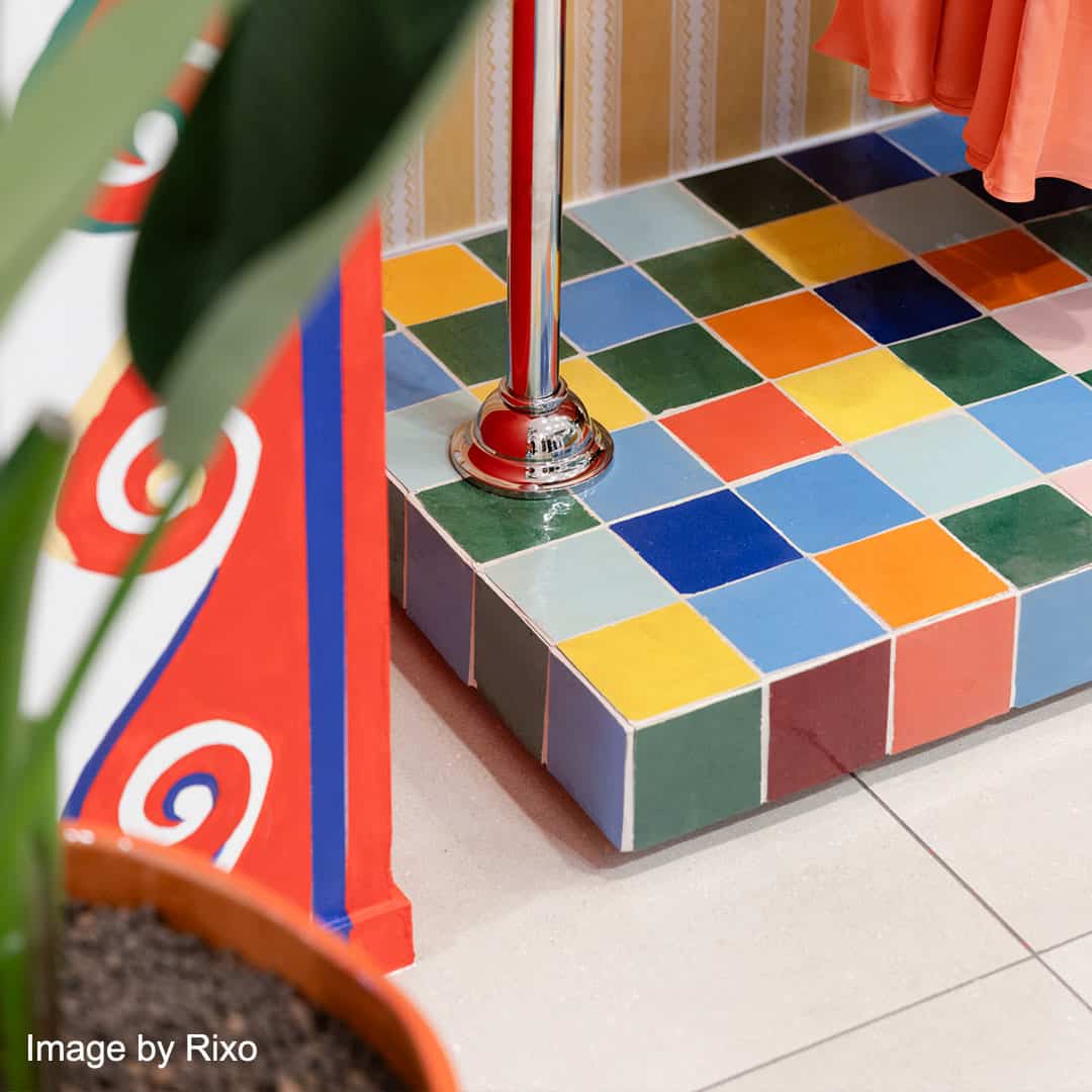 Colorful tiled floor with a plant and a flag in the foreground