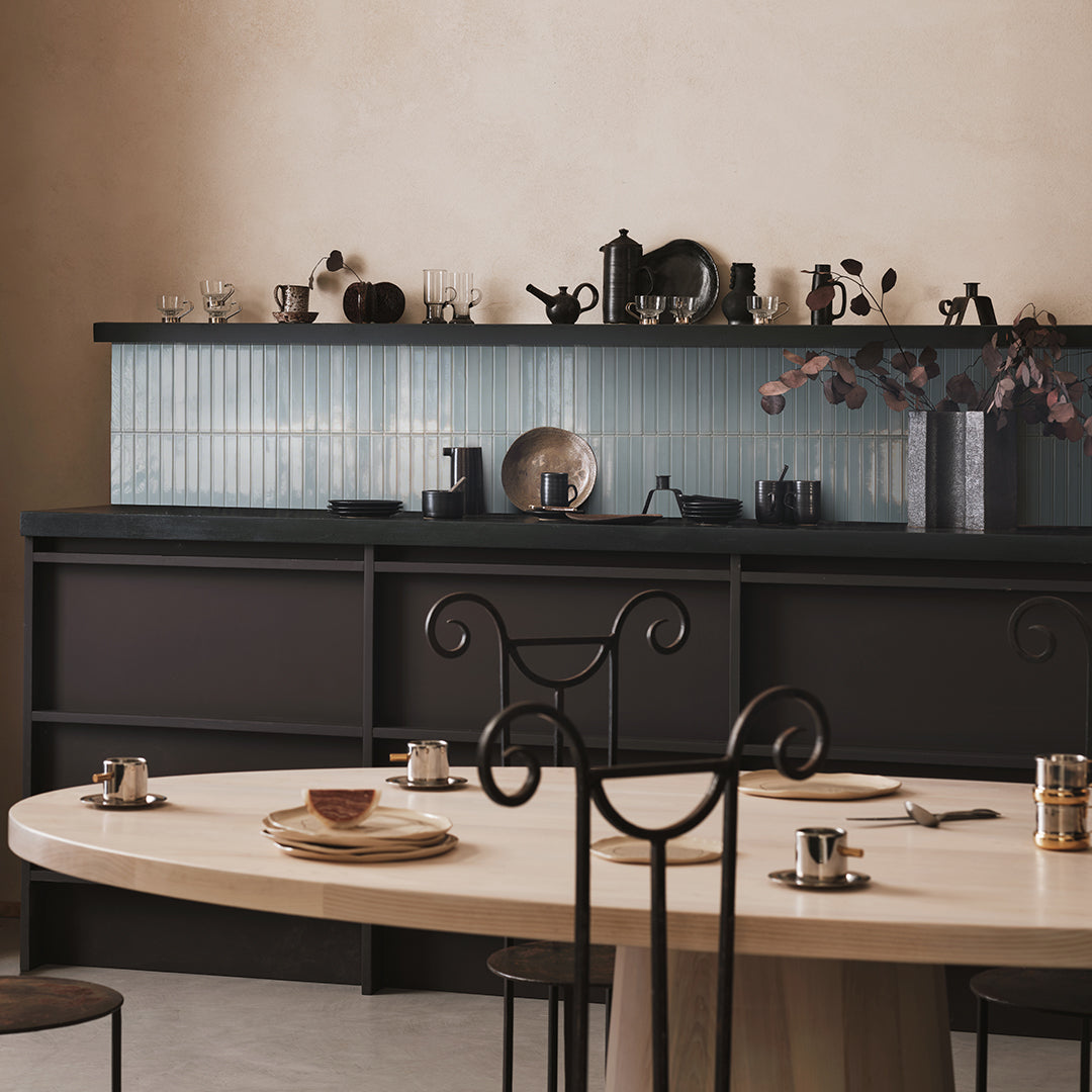 Modern kitchen with black island and dining table setup