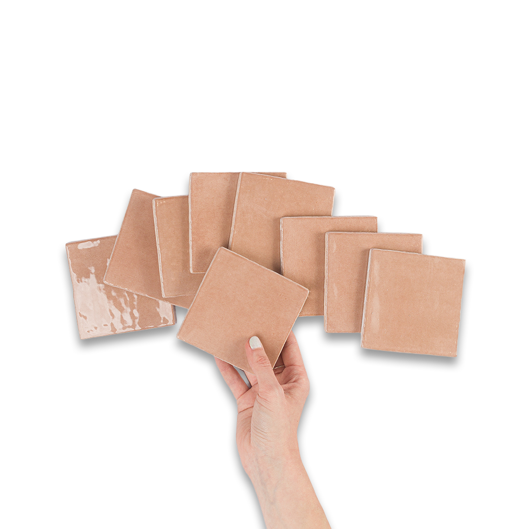 Set of square ceramic tiles with a hand holding one tile on a white background